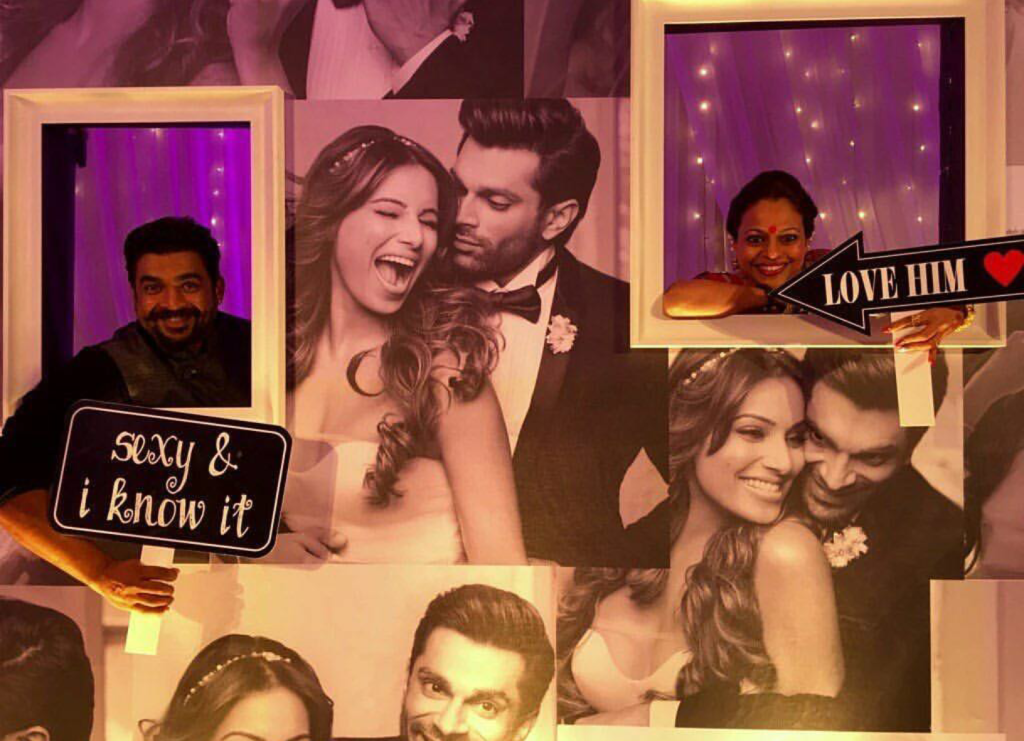 Madhavani and his wife posing with the cool wedding backdrop