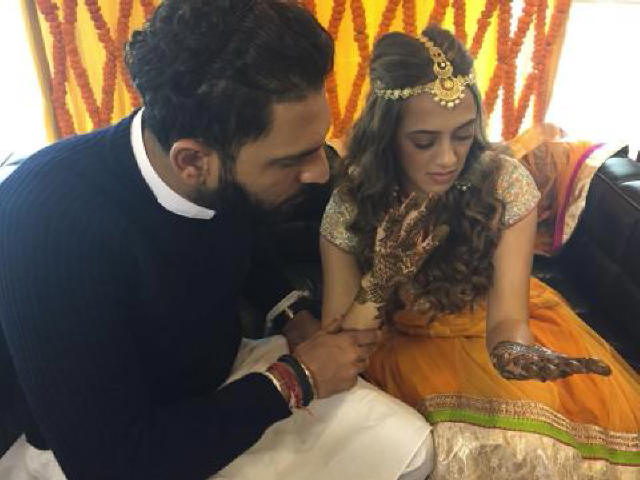 Yuvraj trying to find his initials in her mehendi?